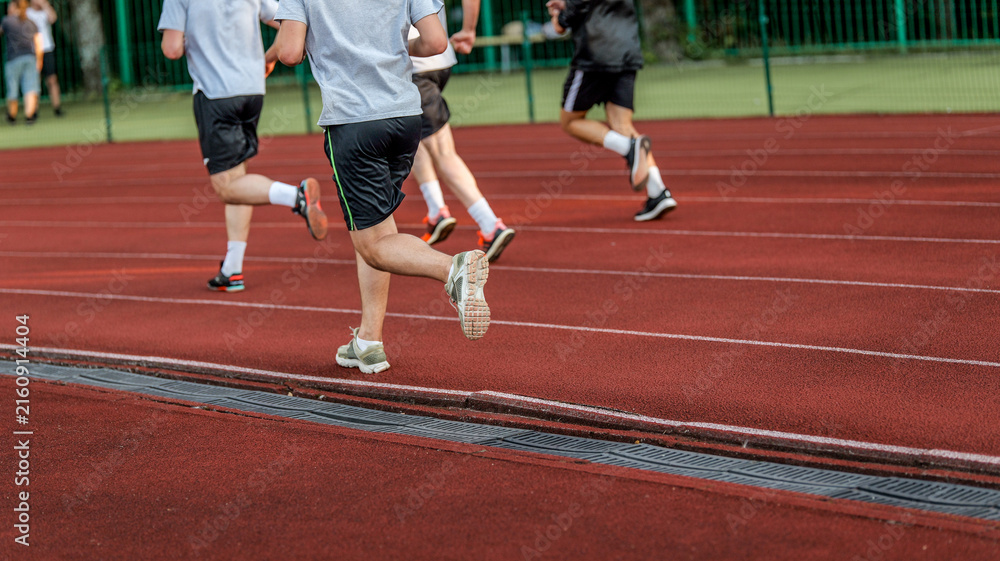 Fototapeta premium Athletes running on a red track during a race or training session