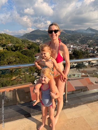 Fotografie Mère avec ses deux filles devant un panorama montagneux au Sri Lanka