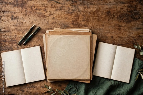 Rustic Stack of Stationery, Journals, and Kraft Paper on Wood