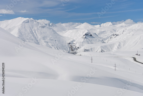 Aerial drone view of Gudauri ski resort in Georgia surrounded by snow covered Caucasus Mountains, with fresh white snow, pristine winter landscape and dramatic alpine scenery
