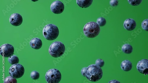 Fresh blueberries falling in slow motion against a vibrant green background with cinematic lighting and gentle camera movement