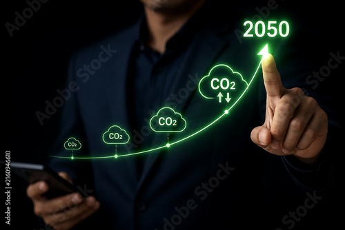 Businessman pointing at glowing co2 and 2050 target graph on dark background