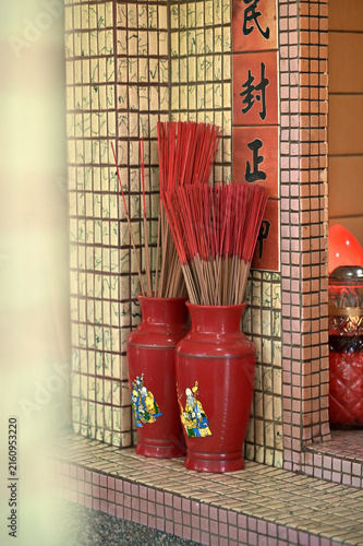 Obraz na plátně Yilan County, Taiwan - Aug 09, 2025: Ceramic incense urns filled with joss sticks stand at an Earth God shrine, mosaic tiles behind