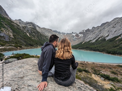 Konstfotografi A couple relaxing and enjoying the stunning turquoise waters of Laguna Esmeralda, surrounded by mountains in Tierra del Fuego, Argentina