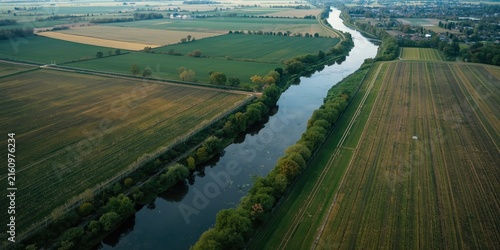 Aerial View of Lush Green Fields and Meandering River Under Clear Sky