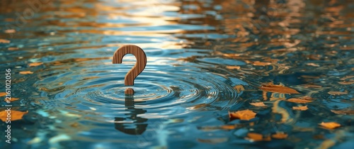 Wooden Question Mark Floating on Water with Autumn Leaves and Ripples