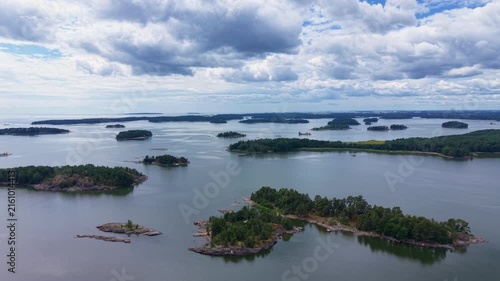 Aerial view of the Finnish archipelago with numerous forested islands scattered across calm Baltic Sea waters under a dramatic cloudy sky near Gulf of Finland