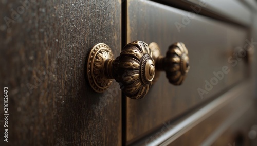 Detailed Closeup of Vintage Drawer Handles on Dark Wooden Furniture