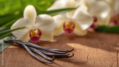 Orchids and Vanilla Beans on a Wooden Surface with Soft Natural Light