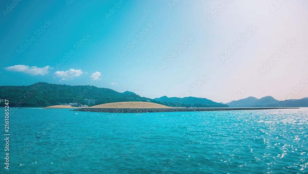 Naklejka premium Tropical Seascape with Idyllic Islands and Clear Blue Waters Under Bright Sky