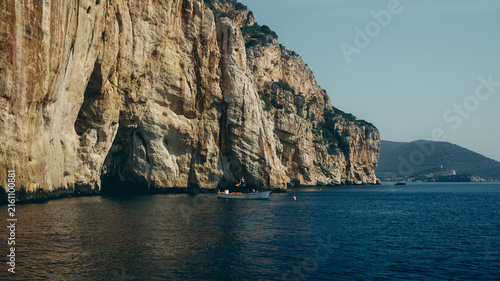 boat by the cliffs at sunset