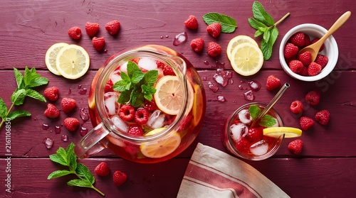 Refreshing raspberry and lemon infused drink with ice and mint garnish