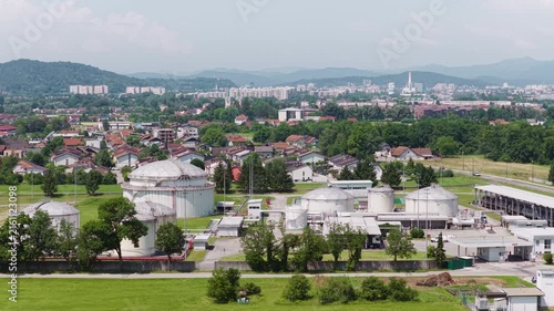 Aerial view shows a petroleum storage facility with multiple tanks and pipelines. This site supports fuel distribution and energy supply.