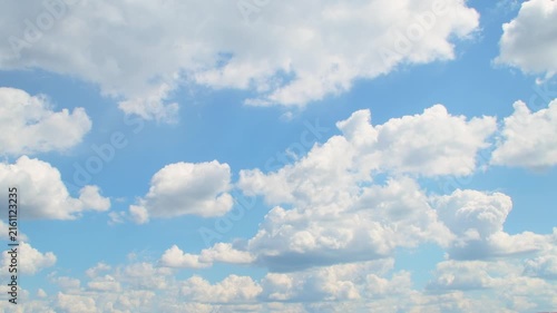 Slowly floating white cumulus clouds. A calm blue sky with fluffy clouds in summer.