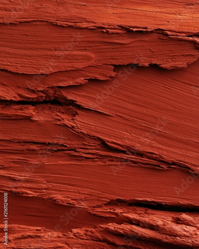 Red cracked clay texture background with layered flaky surface for natural design, poster, packaging and background use