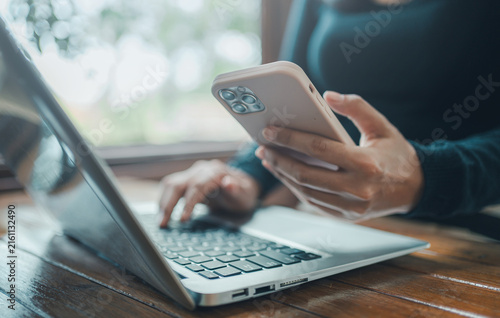 Digital lifestyle and mobile banking business concept, professional woman hands using smartphone and typing on laptop computer for e-commerce online shopping and remote work communication technology
