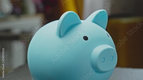 Blue piggy bank rotating indoors. Concept of financial planning and investment. Saving money for future use. Close-up in 4K, UHD