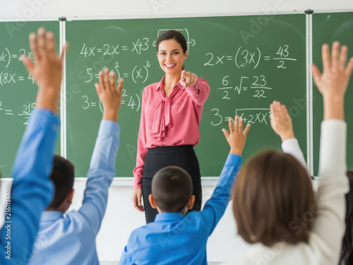 Smiling female teacher pointing at student in a math classroom setting