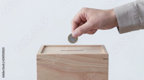 Charity donation hand placing coin in wooden box esg concept savings support