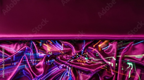 Abstract purple and pink neon light trails with dark background.