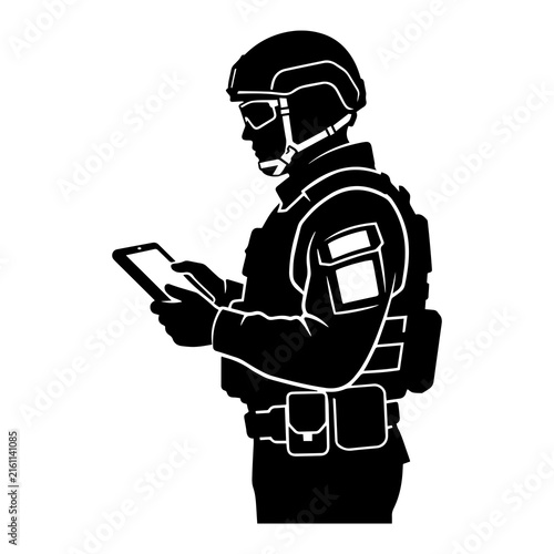Special operations soldier silhouette using digital tablet for tactical planning and communication wearing combat gear.
