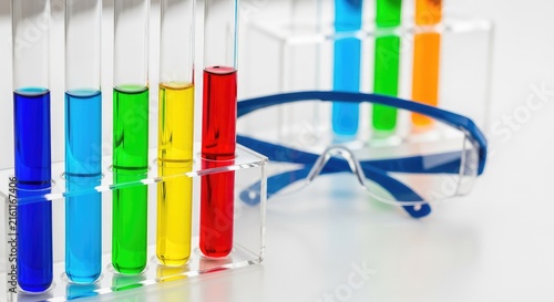 Detailed close up of glass test tubes containing chemical solutions held near protective safety goggles within a modern research laboratory, protection, chemical, research