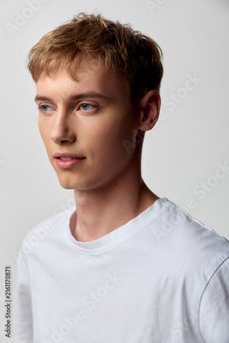 Youthful male in a white tee stands in a studio with soft lighting, calm expression and clean background, ideal for modeling and lifestyle use, a modern headshot with versatile, marketable appeal