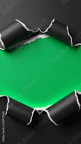 Black paper torn open to reveal vibrant green space inside