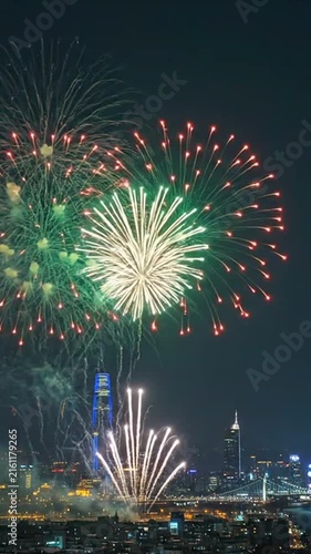 Bright colorful fireworks illuminating the night sky above a glowing modern city