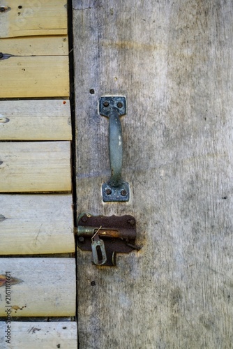 Fotografie Close up detail of an old metal door handle and rusty latch on a traditional wooden and bamboo door
