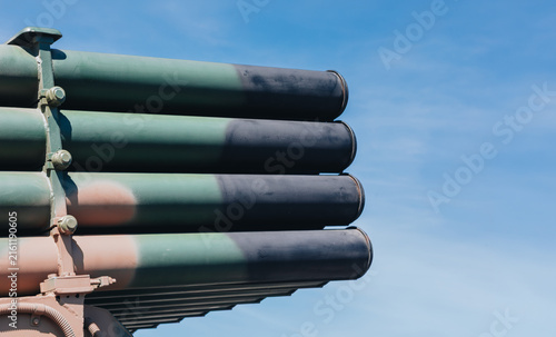Foto Camouflaged Multiple Rocket Launcher Tubes in Close-Up Against Blue Sky with Cop