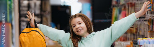 Фотография Cute schoolgirl enjoys back to school shopping in a colorful stationery store