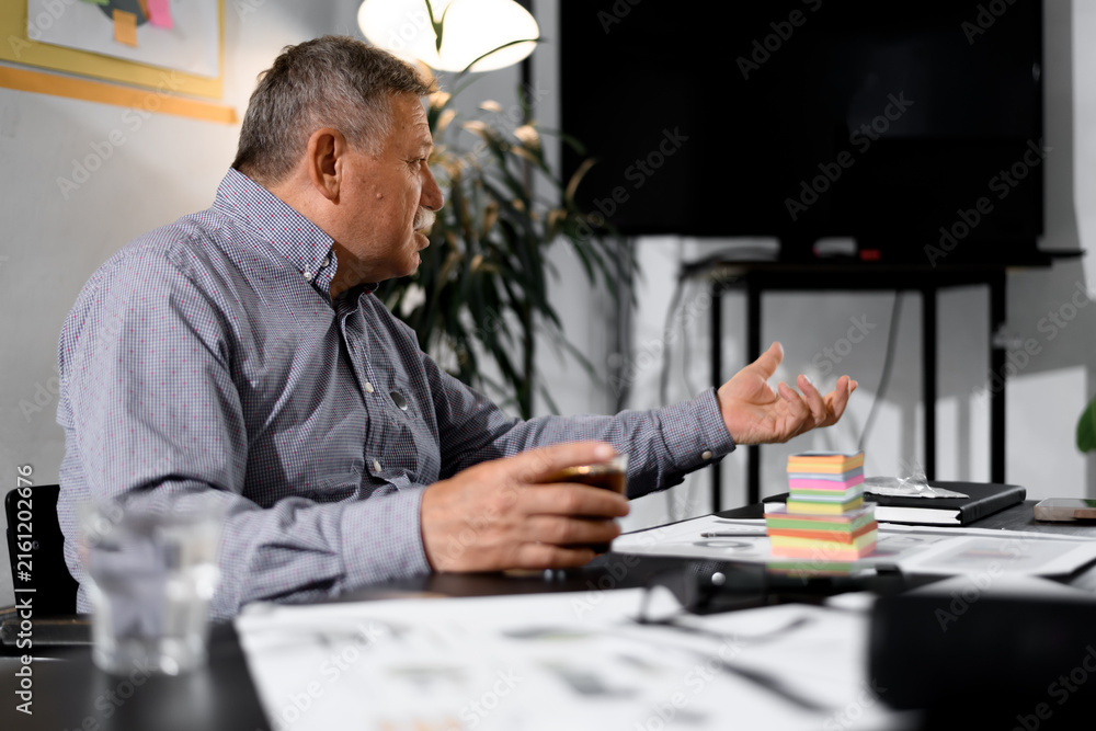 Fototapeta premium Businessman discussing ideas in a modern office setting with sticky notes and documents on the table during a productive meeting