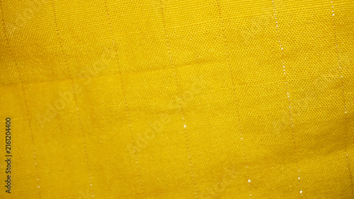 Bright yellow woven fabric texture with subtle sparkle detail.