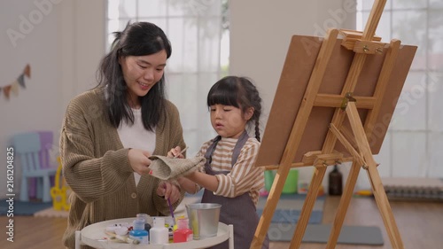 Mother Daughter Painting at Home with Easel and Art Supplies, Creative Family Activity with Child, Woman and Clay Sculpture, Joyful Art Moment Supporting Creativity in Bright Room