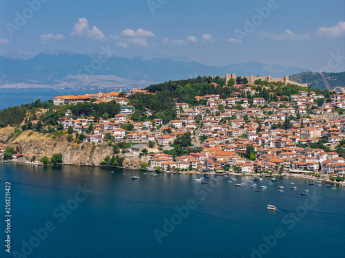 Aerial drone view of Ohrid in North Macedonia during summer, featuring historic old town, UNESCO heritage landmarks, harbor and crystal clear Lake Ohrid surrounded by scenic landscape