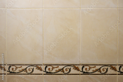 Obraz na plátně Large beige ceramic tiles with subtle marble-like veining form a clean wall surf