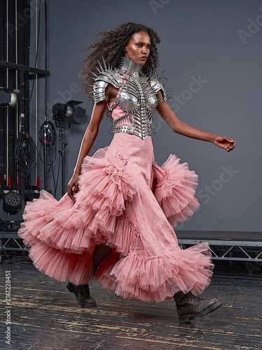 Fierce Fashion Model Wearing Pink Tulle Gown and Spiked Metal Armor on Studio Runway