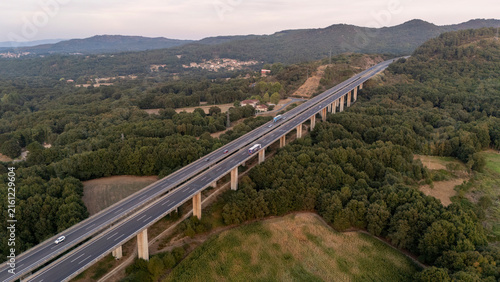 Elevated highway viaduct crossing green forest in Galicia, Spain
