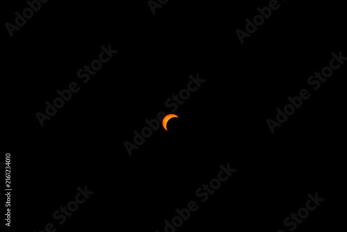 Cuadro en lienzo Small crescent sun during a partial solar eclipse on black background with copy
