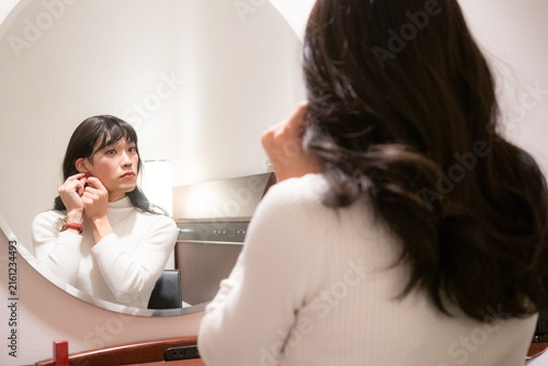 鏡の前で身支度をする女性