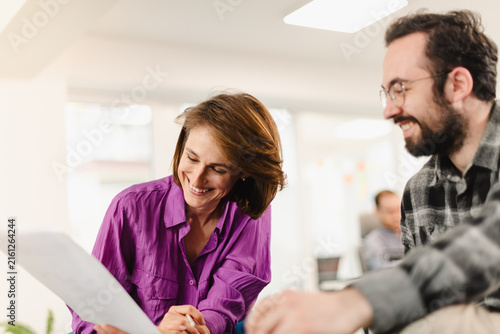 Two businesspeople engaging in a discussion about project plans in a modern office setting during a weekday morning