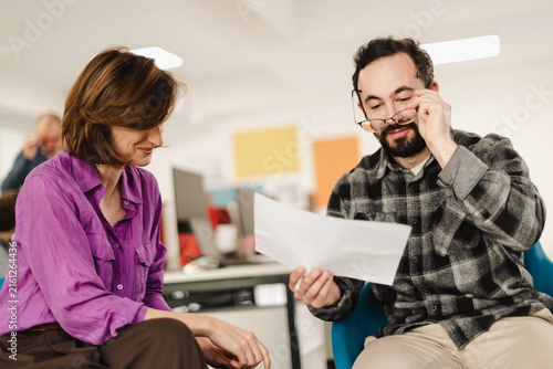 Discussing project details in a modern office space with businesspeople focused on tasks in a collaborative environment