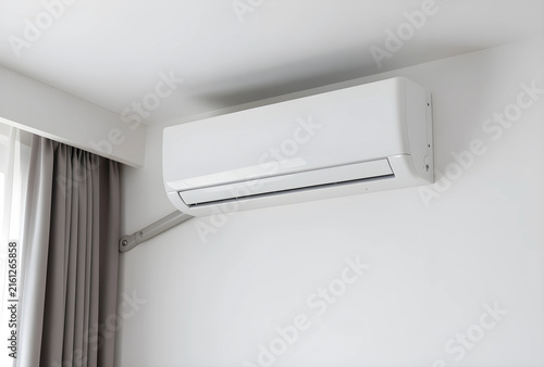 Home cooling and climate control, modern white air conditioner unit installed on a clean wall in a residential room