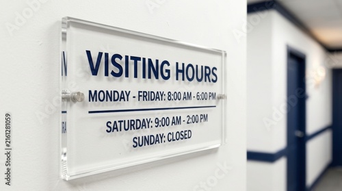 Clear Acrylic Visiting Hours Sign Mounted On A White Wall Providing Important Information
