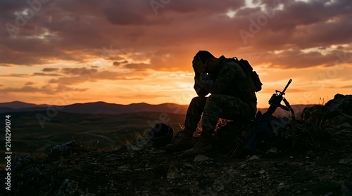 Silhouetted soldier resting on rocky terrain during sunset in expansive landscapes capturing tranquility and resilience in