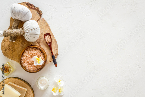 Spa set with massage herbal balls in wellness salon on white background top view space for text