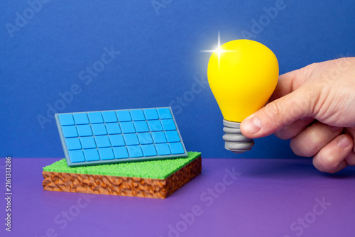The light bulb is powered by a solar battery. The light bulb is an idea and a technological innovation. Renewable energy generation and storage. Modern green technology.