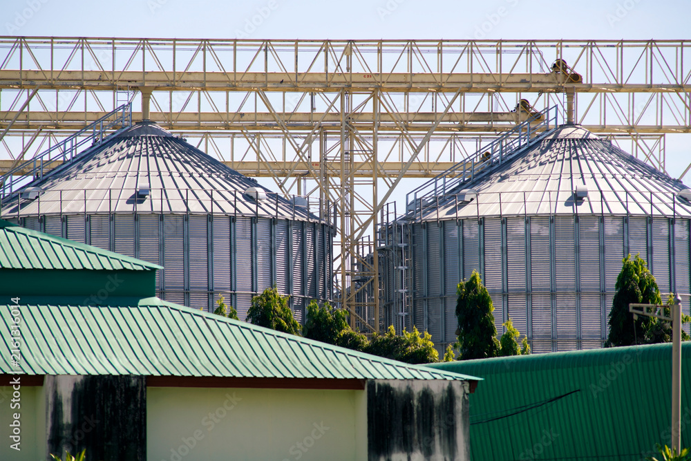 Naklejka premium Industrial Grain Storage Silos with Connecting Framework and Green Roofs