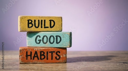 Stacked colorful wooden blocks with build good habits text